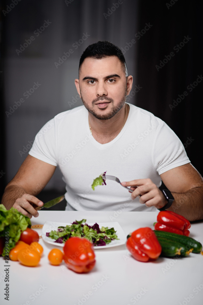 Beautiful man to eat healthy vegetarian food at home. The concept of a healthy lifestyle Beautiful man to eat healthy vegetarian food at home. The concept of a healthy lifestyle