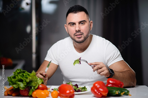 Beautiful man to eat healthy vegetarian food at home. The concept of a healthy lifestyle