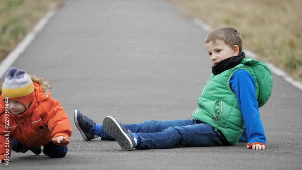 Baby child and brother on alley, baby move away crawling Baby child and brother on alley, baby move away crawling