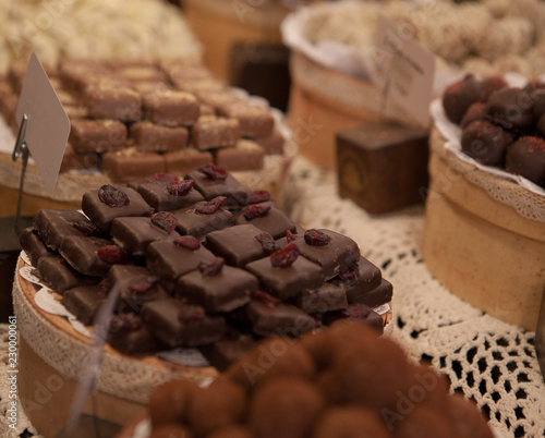 Asorted chocolate truffles and pralines. Chocolate and coconut candies on the counter in the confectionery store photo