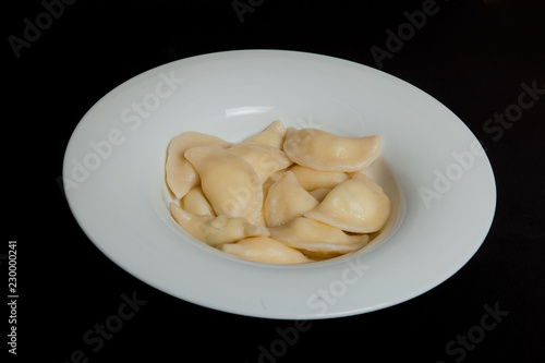 Spinach Dumplings in a white plate on a black background