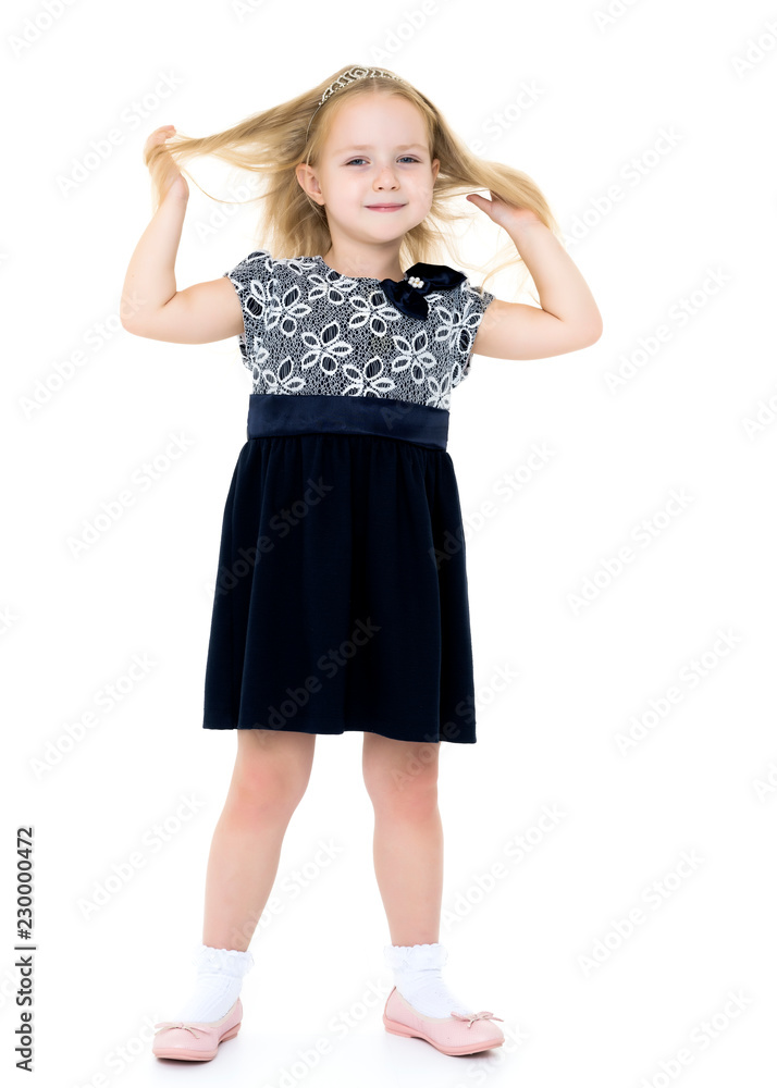 A little girl fixes her hair. A little girl fixes her hair.