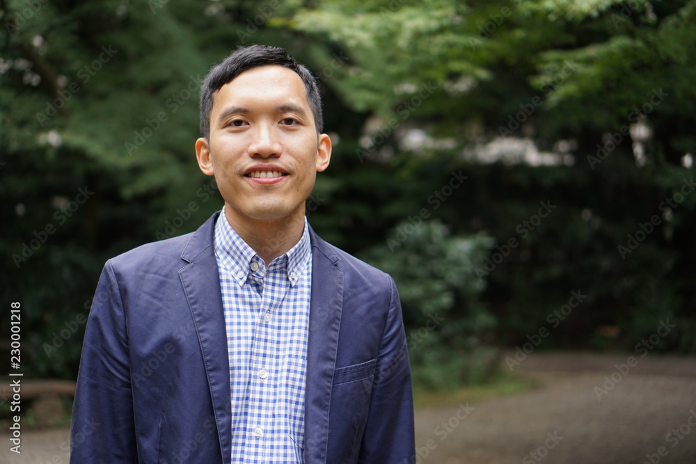 Portrait of a southeast asian young man smiling in a park Portrait of a southeast asian young man smiling in a park
