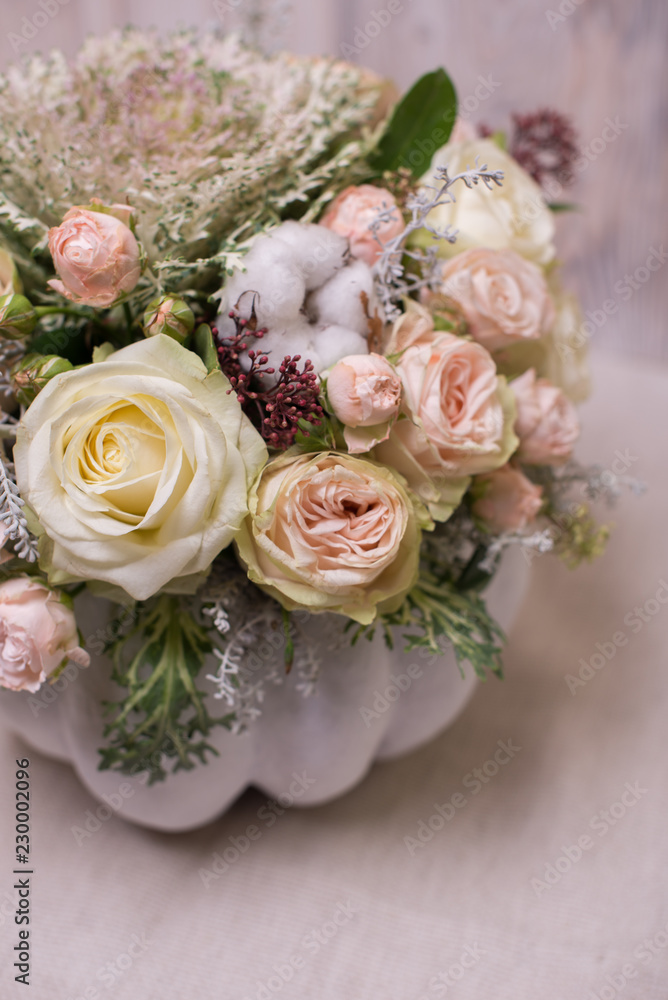floral bouquet in a white pumpkin on a light background, a mixture of flowers, peony rose, eucalyptus, chrysanthemum, Brassica, white orchid, cotton