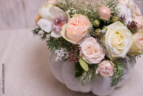 floral bouquet in a white pumpkin on a light background, a mixture of flowers, peony rose, eucalyptus, chrysanthemum, Brassica, white orchid, cotton