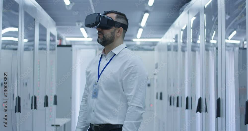 Medium shot of an electrical worker using a VR headset in the control room of an electrical station Medium shot of an electrical worker using a VR headset in the control room of an electrical station