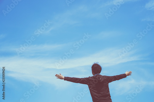 Man rise hands up to sky freedom concept with blue sky and summer background.