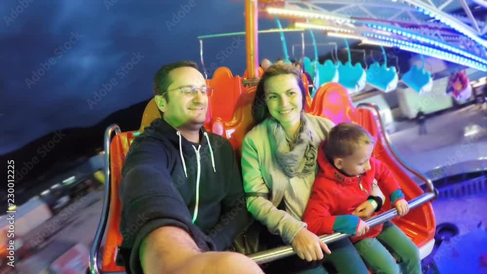 Child and parent have fun at amusement park, night entertainment Child and parent have fun at amusement park, night entertainment