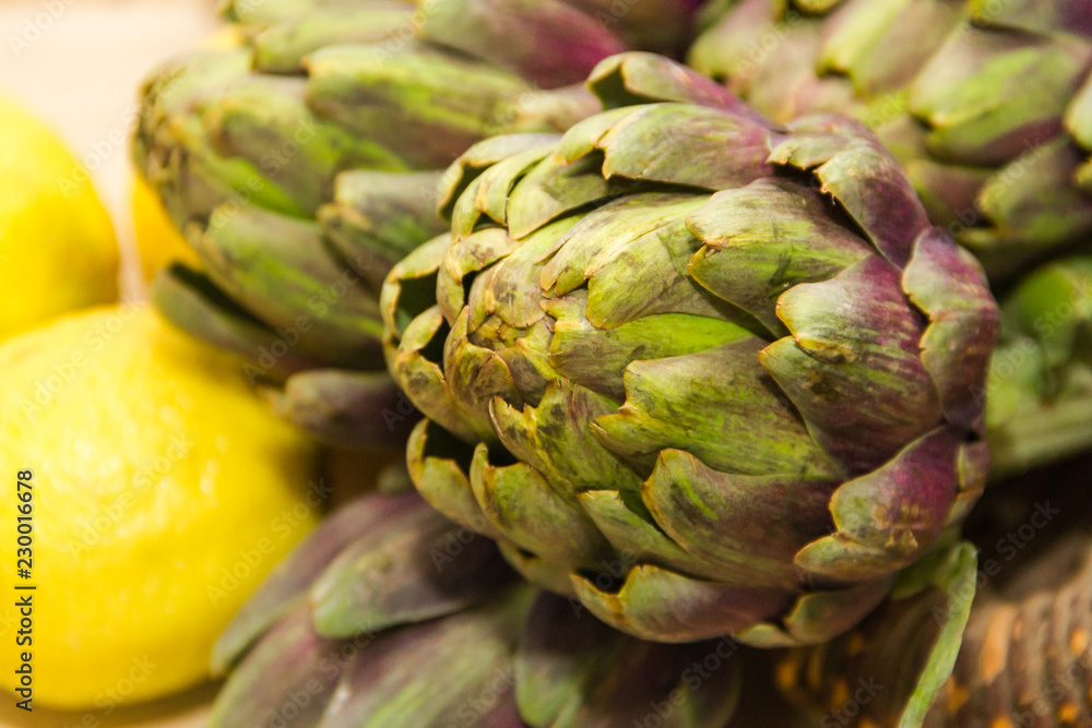 artichokes cooked with lemon and salt on rustic wooden background