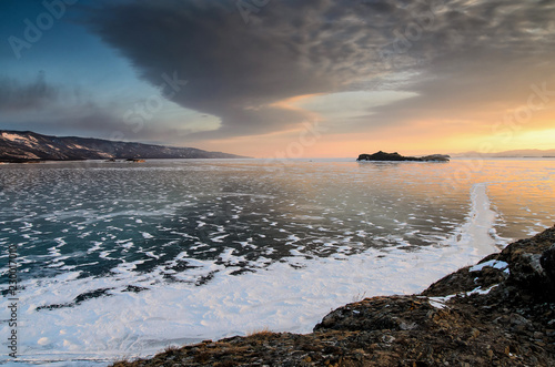 Frozen Lake Baikal. Beautiful stratus clouds over the ice surface on a frosty day.