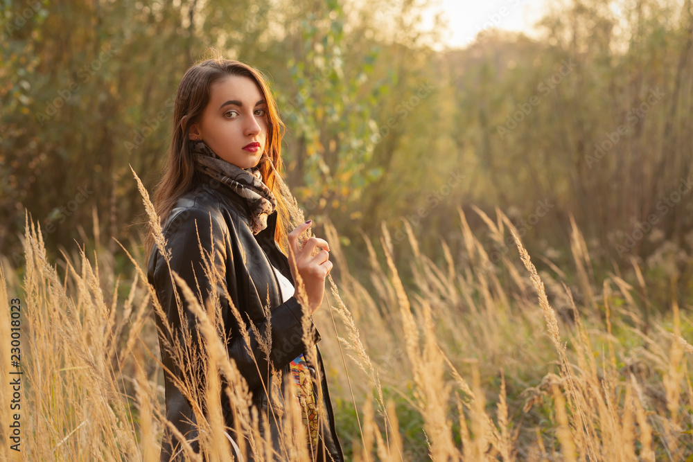 beautiful sad young woman walking at dry grass, looking at camera beautiful sad young woman walking at dry grass, looking at camera