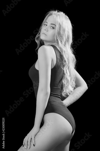 beautiful young woman show her slim body on black background, monochrome