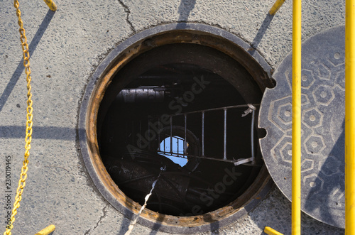 Open manhole on a city street photo