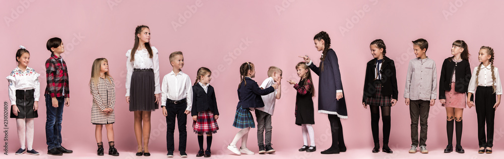 Cute smiling happy stylish children on pink background. Beautiful stylish teen girls and boy standing together and posing at studio. Classic style. Kids fashion and emotions concept. Cute smiling happy stylish children on pink background. Beautiful stylish teen girls and boy standing together and posing at studio. Classic style. Kids fashion and emotions concept.