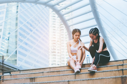 Group of sporty female friends sitting on the steps of the city