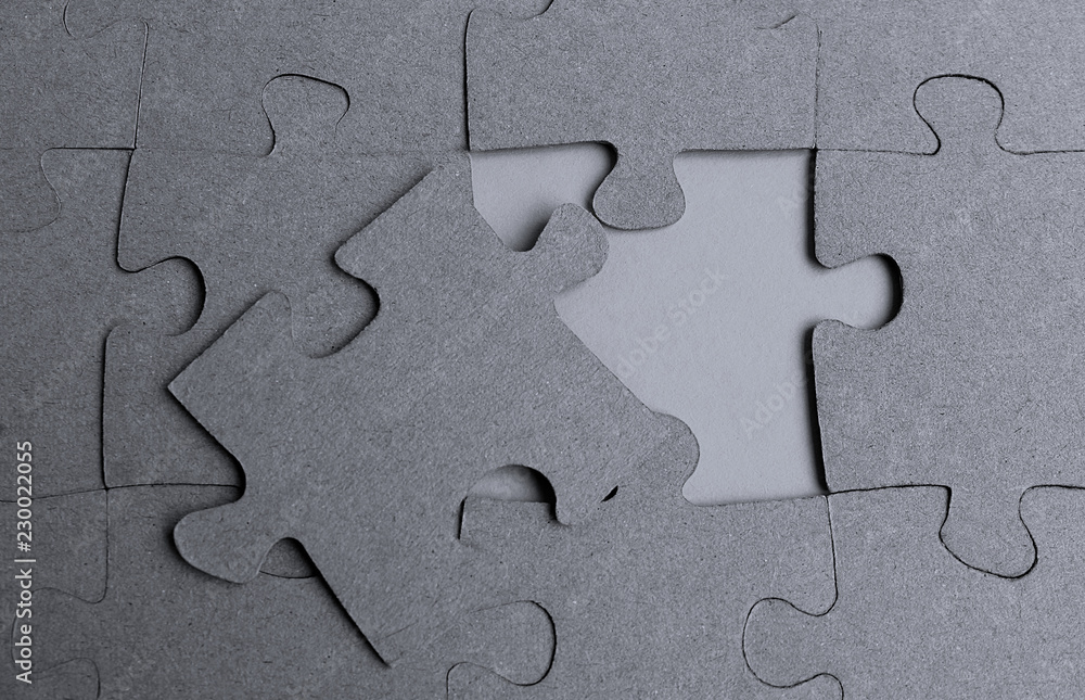 Gray puzzles laid out on the table on a gray background Gray puzzles laid out on the table on a gray background