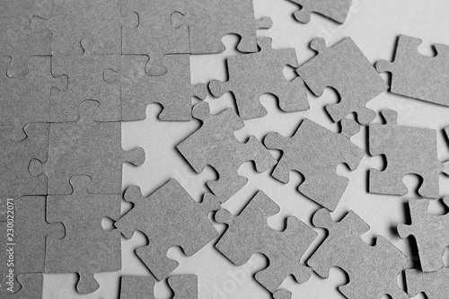 Gray puzzles laid out on the table on a gray background