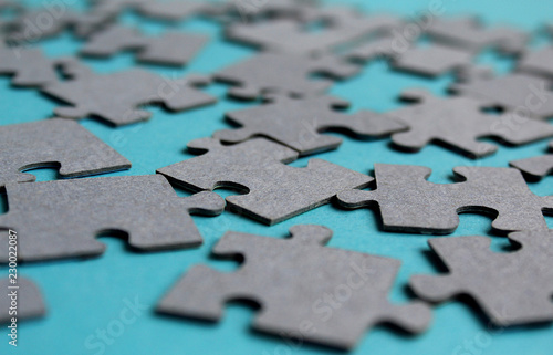 Gray puzzles laid out on the table on a gray background