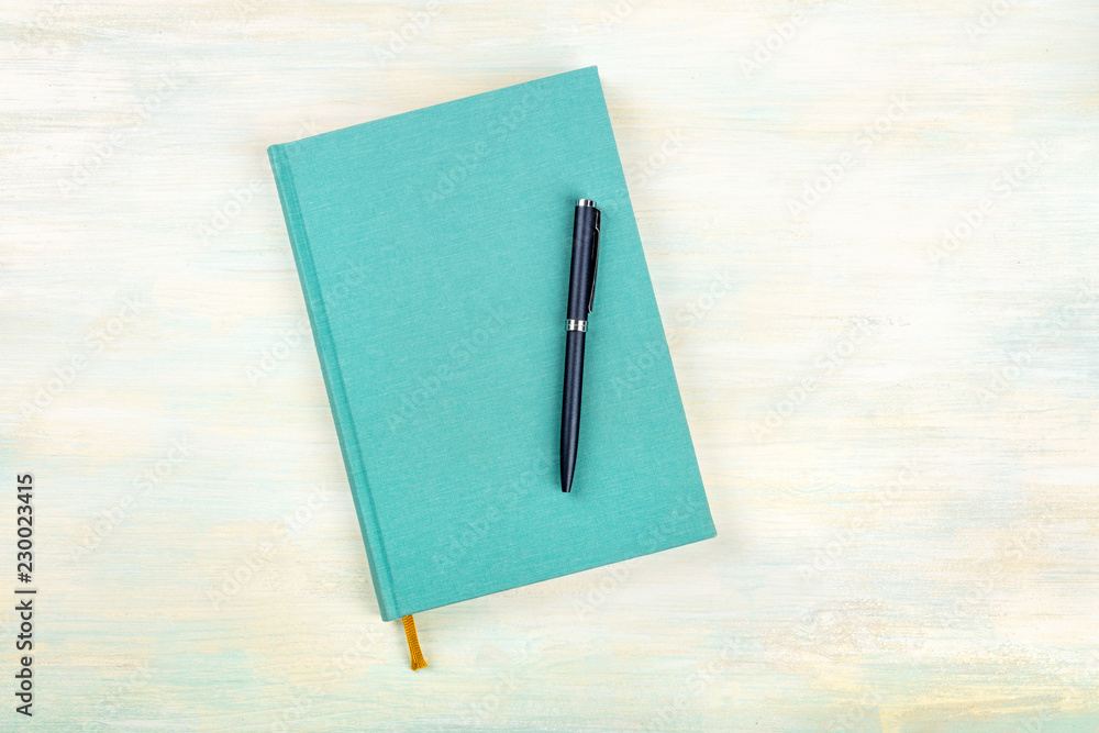Φωτογραφία A photo of a teal blue journal with a pen, an elegant diary, notebook or planner