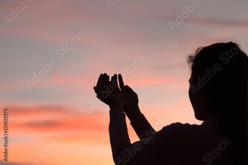Silhouette of woman hands praying to god Woman Pray for god blessing to wishing have a better life. begging for forgiveness and believe in goodness.