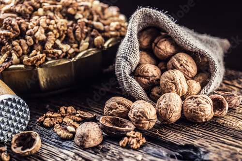 Walnut kernels whole walnuts in burlap sack and vintage bowl photo