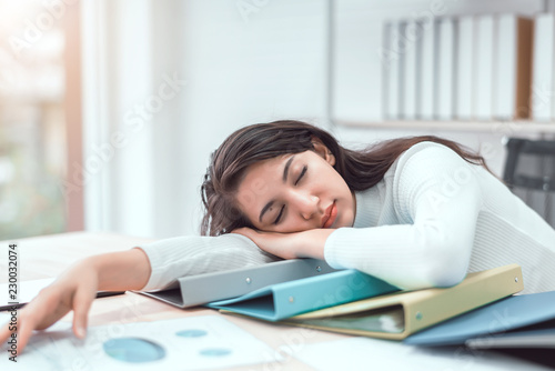 Papier peint Tired businesswoman sleeping with document on the desk at office
