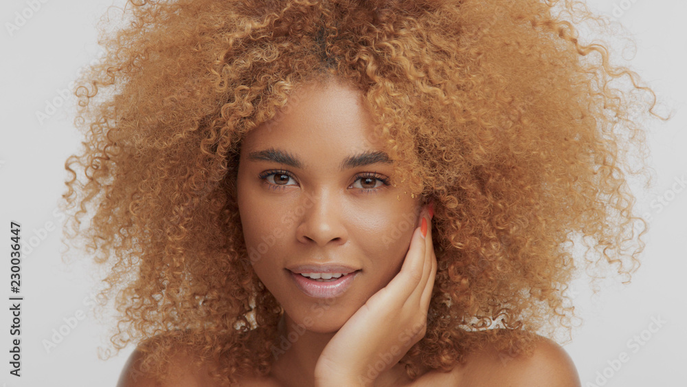mixed race black blonde model with curly hair touching her face Stock Photo  | Adobe Stock