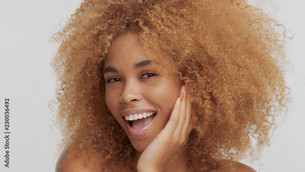 mixed race black blonde model with curly hair and laughing and put her face on hand mixed race black blonde model with curly hair and laughing and put her face on hand