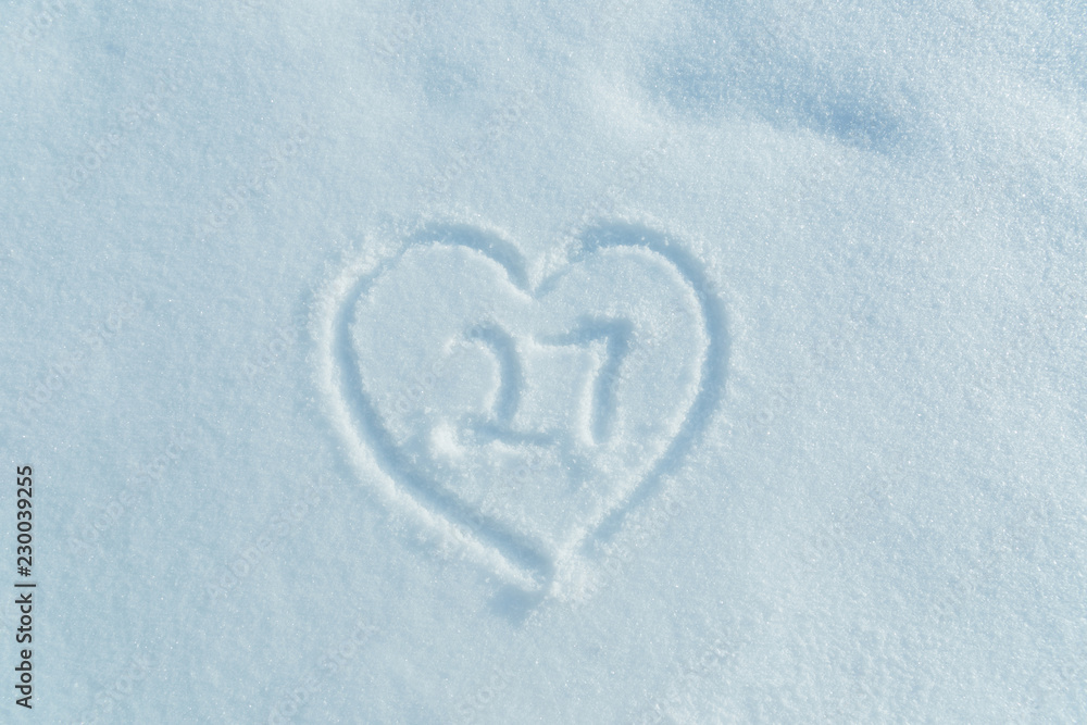 A figure of twenty seven written in the snow in the painted heart. Snow texture. A figure of twenty seven written in the snow in the painted heart. Snow texture.