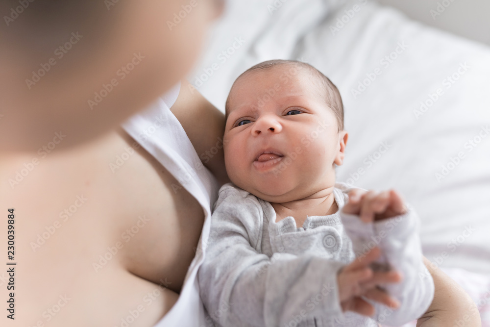 Young happy calm mother and newborn baby resting in bed together. Mom and infant kissing and hugging. Maternity, parenthood, motherhood concept. Young happy calm mother and newborn baby resting in bed together. Mom and infant kissing and hugging. Maternity, parenthood, motherhood concept.