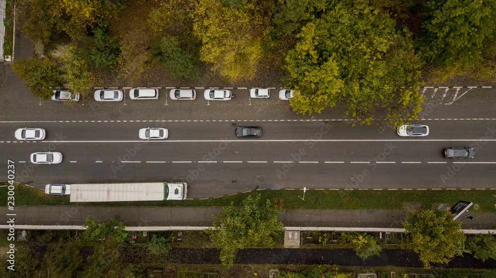 Aerial Drone Flight top down view of freeway busy city rush hour heavy traffic jam highway. Aerial view of the vehicular intersection, traffic at peak hour with cars on the road, fly under trees. Aerial Drone Flight top down view of freeway busy city rush hour heavy traffic jam highway. Aerial view of the vehicular intersection, traffic at peak hour with cars on the road, fly under trees.