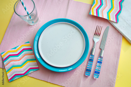 empty plate and blue Cutlery on pink background. concept of preparing to eat