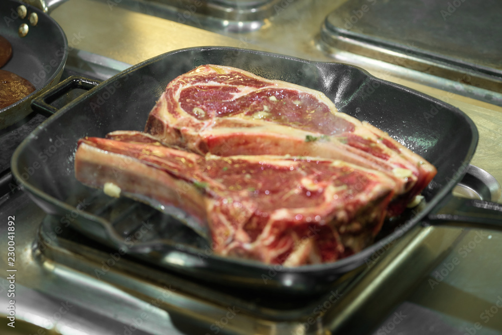 Raw fresh meat T-bone steak on grill iron pan Raw fresh meat T-bone steak on grill iron pan