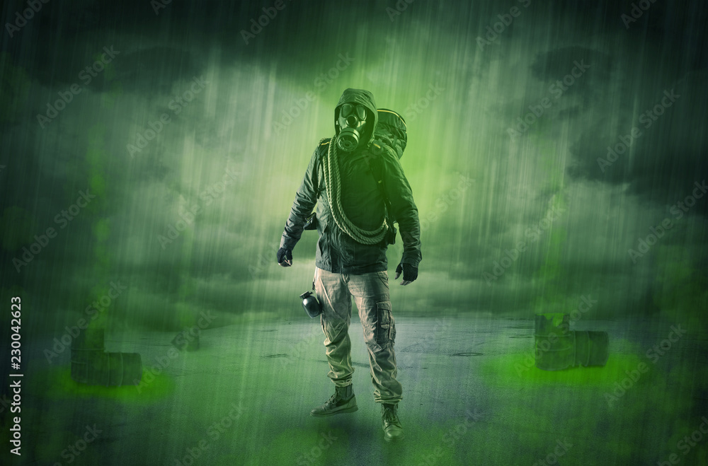 Fototapeta premium Masked unrecognizable guard in an abandoned space after explosion 