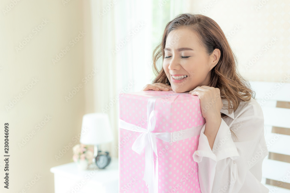 Beautiful Asian women smiling face happy to receive New Year's gift from lovers in the bedroom , Hug gift box Beautiful Asian women smiling face happy to receive New Year's gift from lovers in the bedroom , Hug gift box