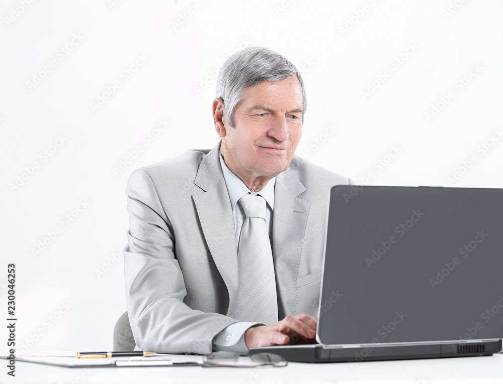 senior businessman working on laptop while sitting at his Desk senior businessman working on laptop while sitting at his Desk