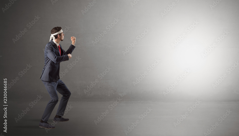 Businessman fighting with boxing gloves in an empty space
