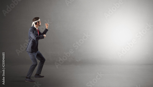 Businessman fighting with boxing gloves in an empty space  