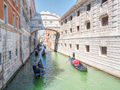Traditional gondolas floating on canal in Venice.