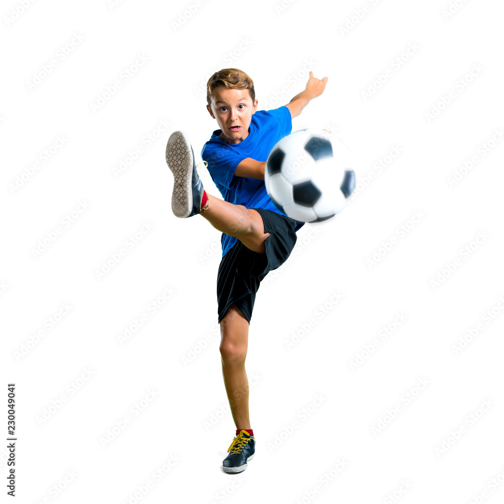 A full-length shot of Boy playing soccer kicking the ball on isolated white background A full-length shot of Boy playing soccer kicking the ball on isolated white background
