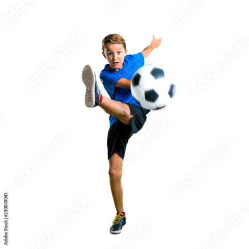A full-length shot of Boy playing soccer kicking the ball on isolated white background