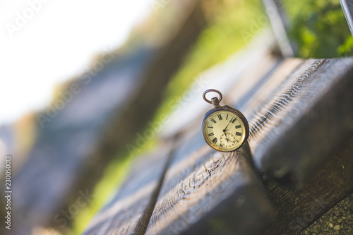 Retro Taschenuhr auf Holzbank, Symbol für Zeit photo