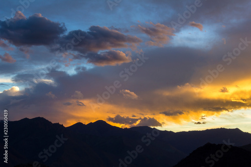 bright colorful sunset sky over mountain silhouettes