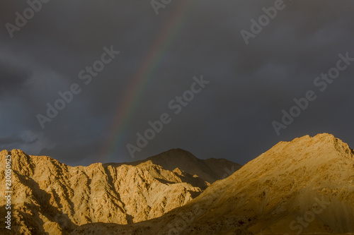 rainbow over the desert mountains in the black evening sky