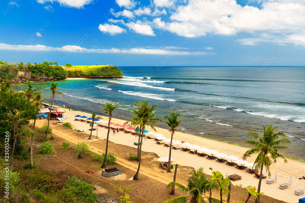 Azure beach with rocky mountains and clear water of Indian ocean at sunny day / Balangan Beach in Bali Indonesia 