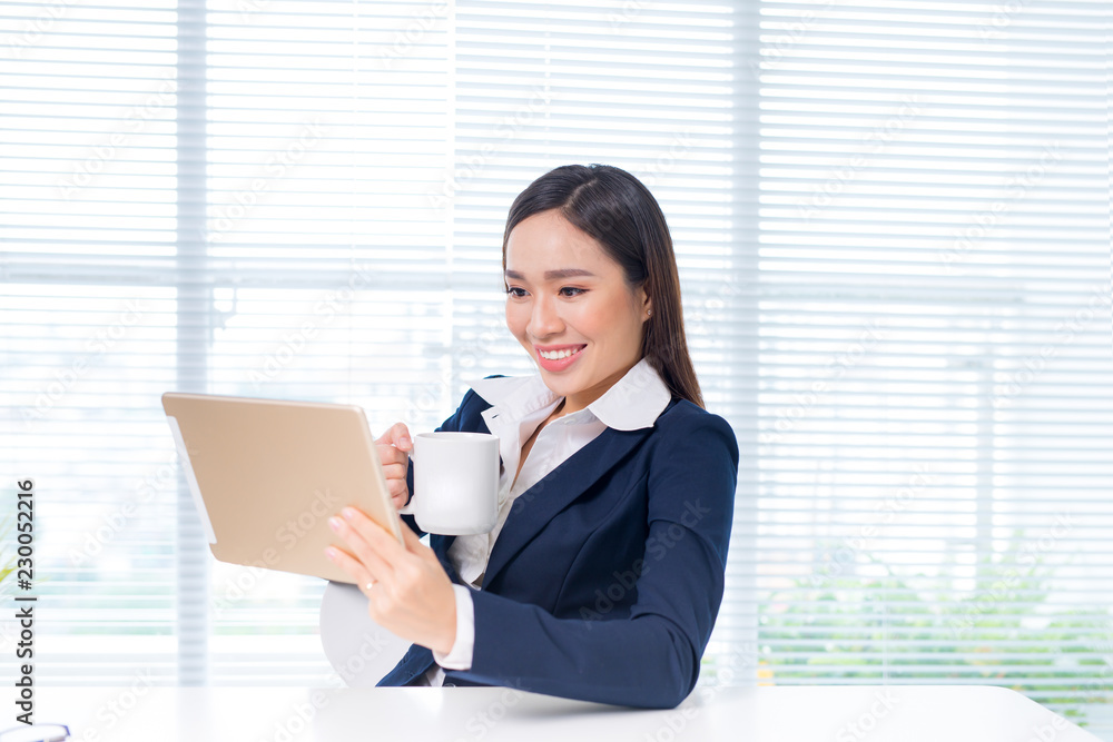 Attractive asian businesswoman working on a digital tablet in the office.