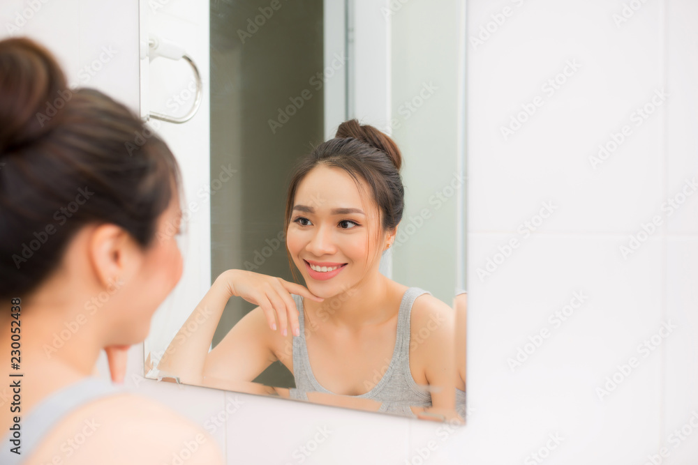 Beautiful woman touching her face by hands in her bathroom Beautiful woman touching her face by hands in her bathroom