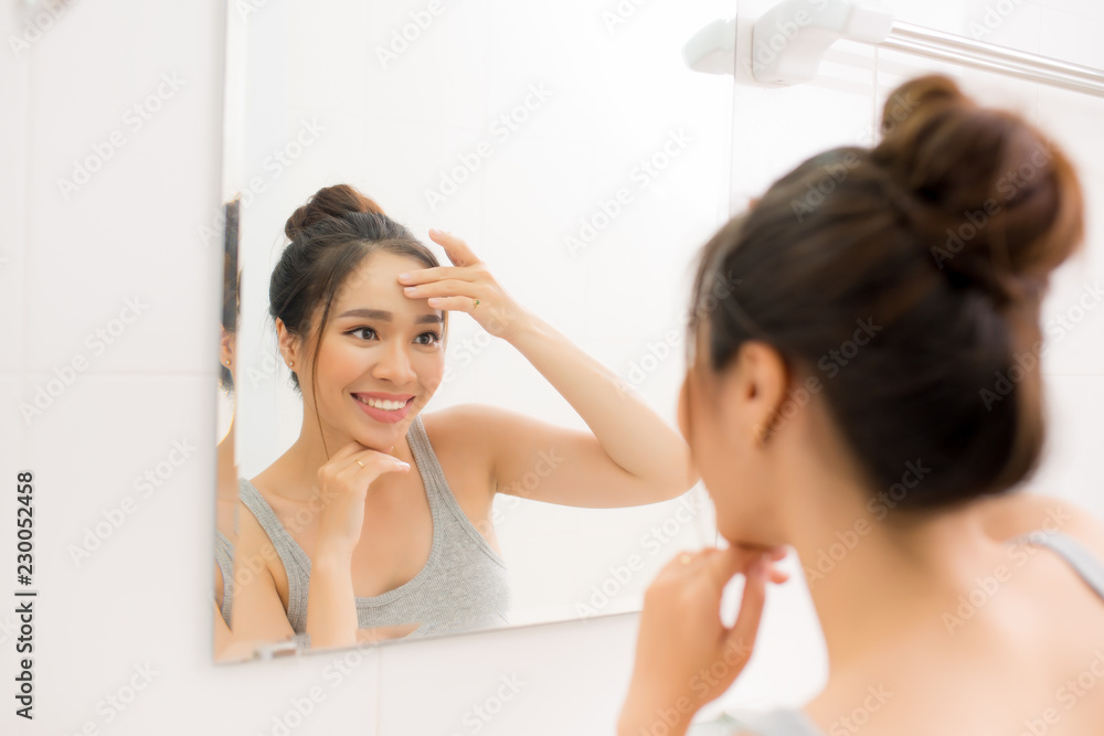 Beautiful woman touching her face by hands in her bathroom Beautiful woman touching her face by hands in her bathroom