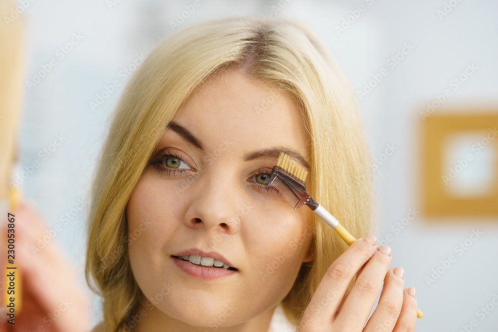 Woman brushing her eyebrows