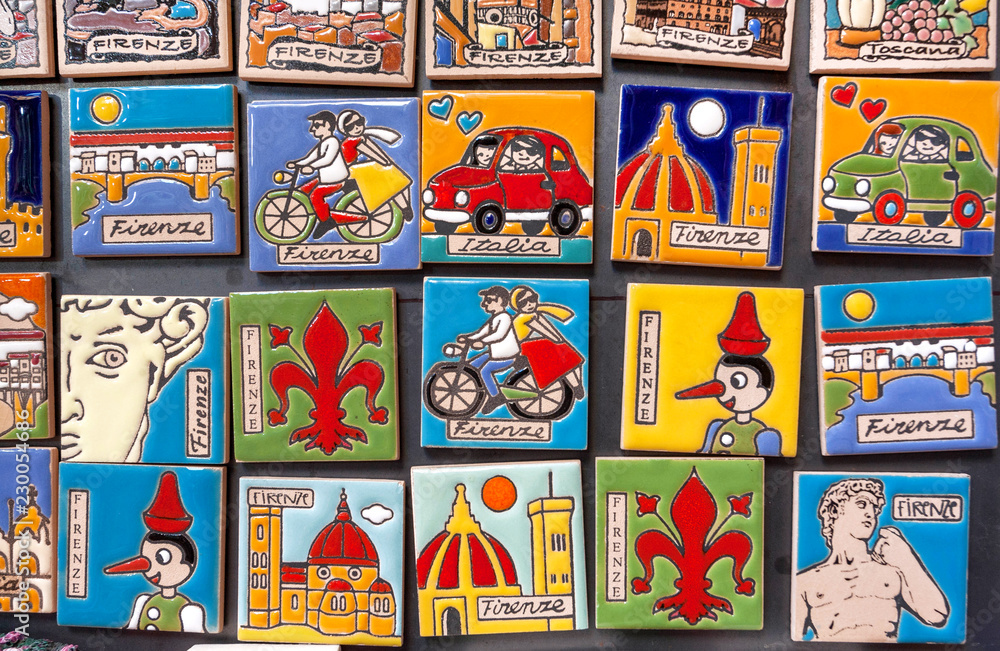 Many colorful souvenir magnets for tourists with popular symbols of Tuscany